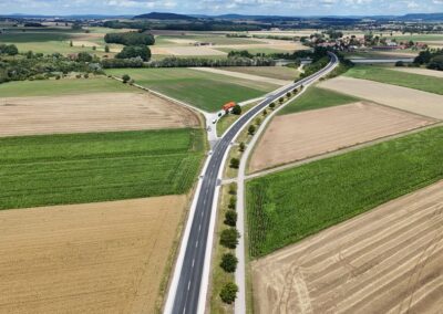 Luftaufnahme: Eine Landstraße trennt grüne und braune Felder bei Allersberg.