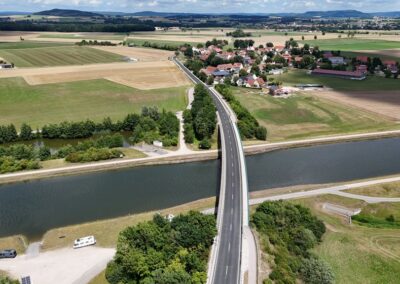 Eine zweispurige Brücke überspannt einen Fluss in der Nähe von Freystadt inmitten einer ländlichen Landschaft.